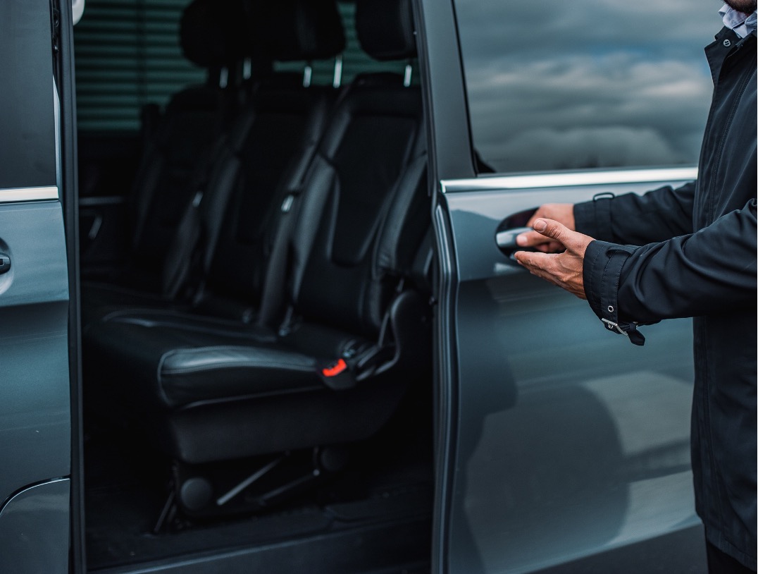 A man opening the door of a vehicle.