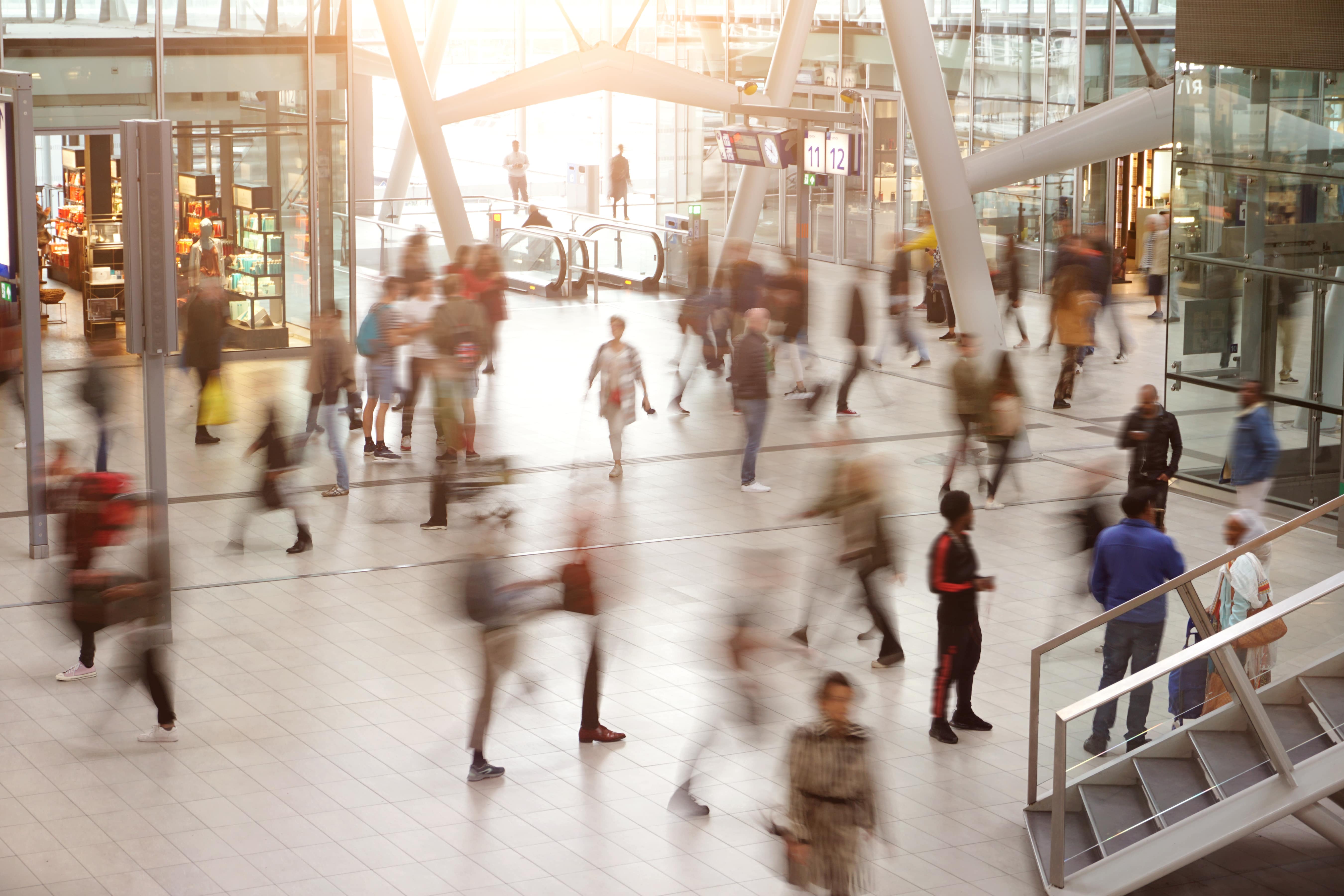 A large group of people walking around a building.