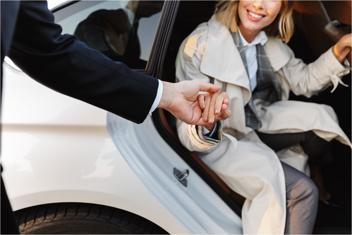 A man and woman sitting in a car holding hands.