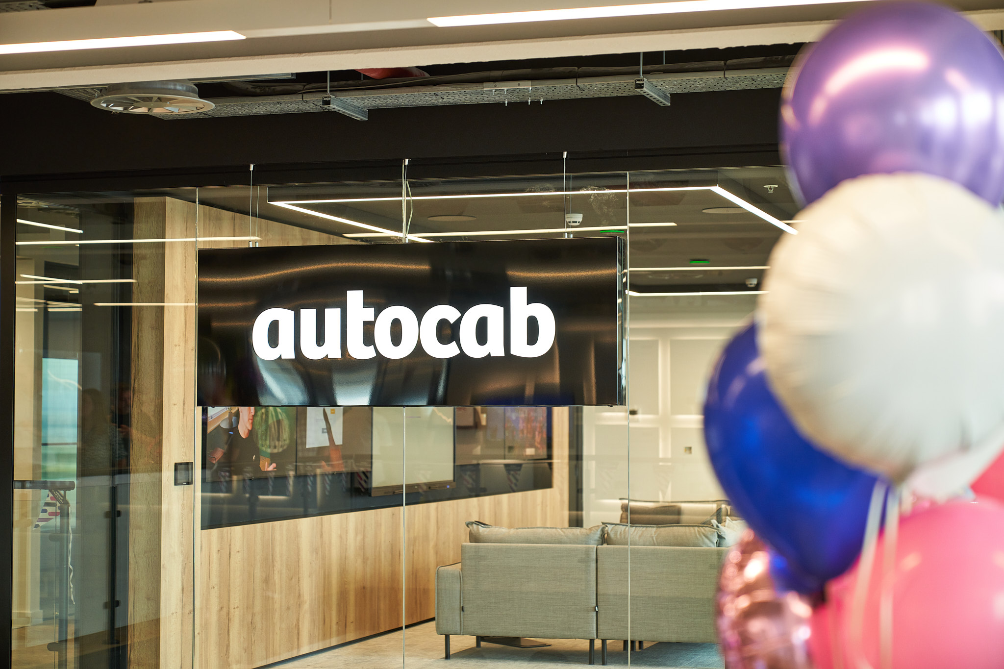 A bunch of balloons are in front of an autocab office
