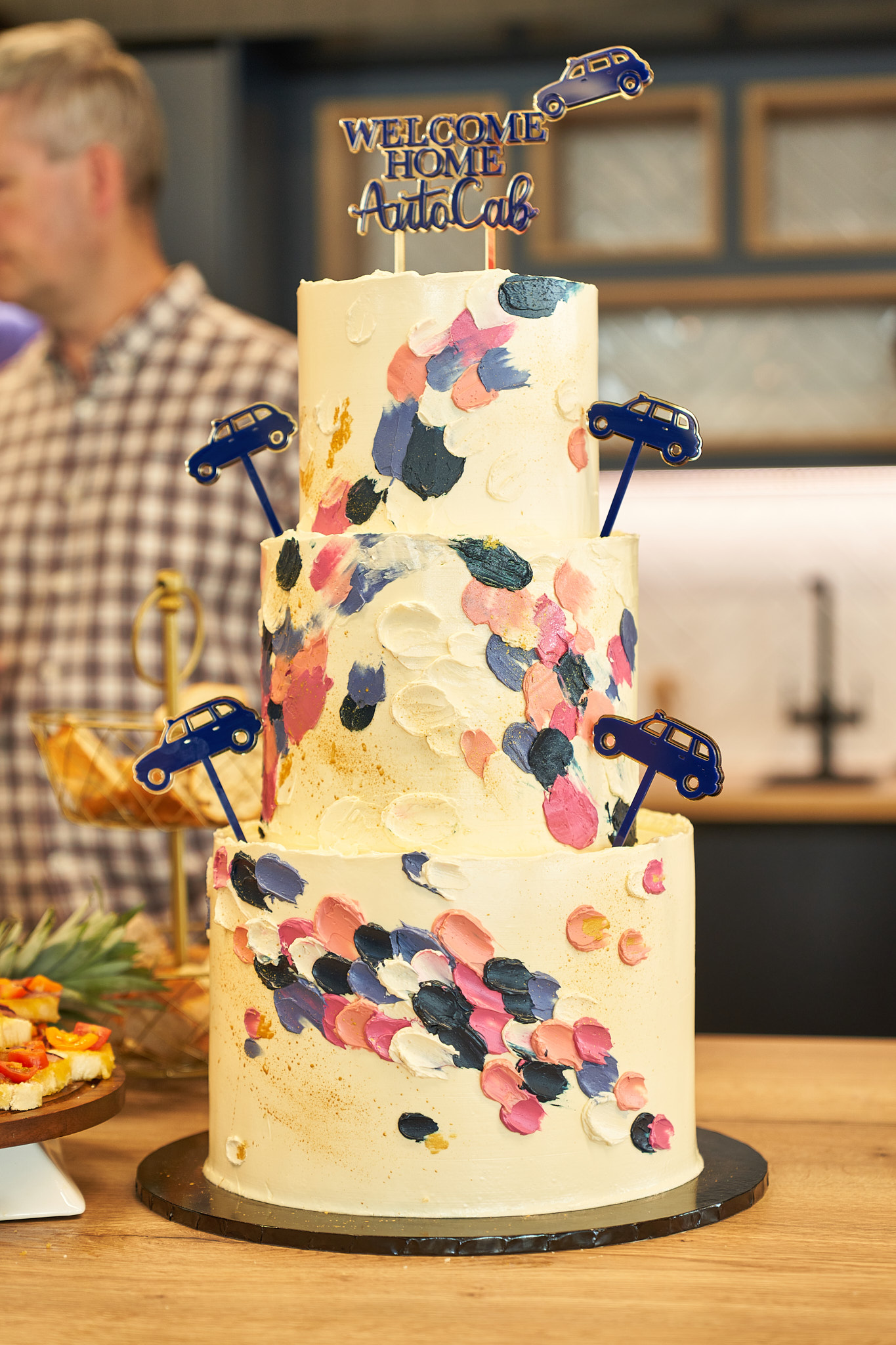 A man standing in front of a decorated cake.