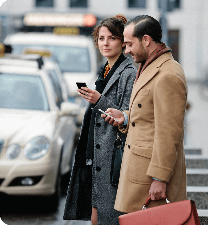 A man and a woman looking at their cell phones.