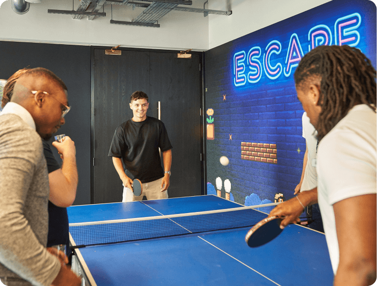 A group of people playing a game of ping pong.