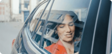 A woman sitting in a car looking out the window.