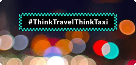 A blurry photo of a street with a sign that says think travel think taxi.